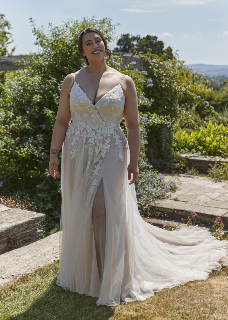 Curvy Brautkleid in A-Linie mit floraler Spitze, die in den Rock überläuft, schmalen Trägern und Schlitz am Bein.